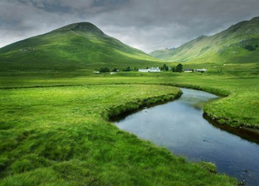 The gentle curve of the river and the light green tones of the grass give this image a calming feel. The montains and the clouds have a less calming effect. Image: courtesy of Icon Photography School - http://www.photographyicon.com/line/